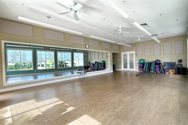 interior space with wood-type flooring, a towering ceiling, and ceiling fan