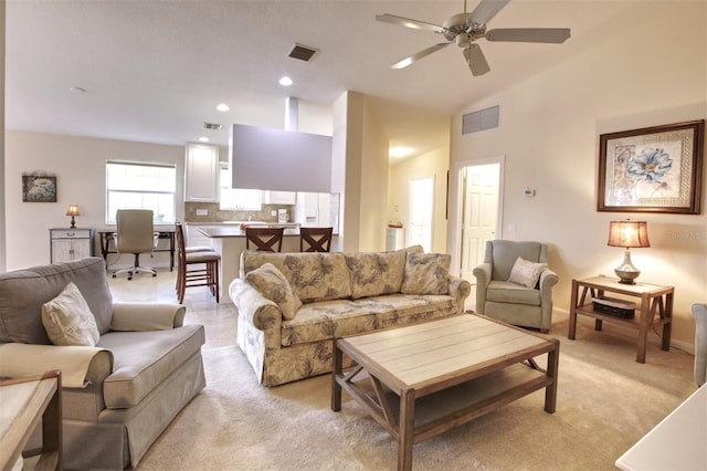 living room with ceiling fan, lofted ceiling, and light carpet