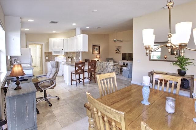 tiled dining area with lofted ceiling, sink, and a notable chandelier