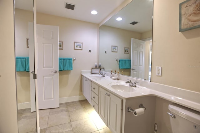 bathroom featuring vanity, tile patterned flooring, and toilet