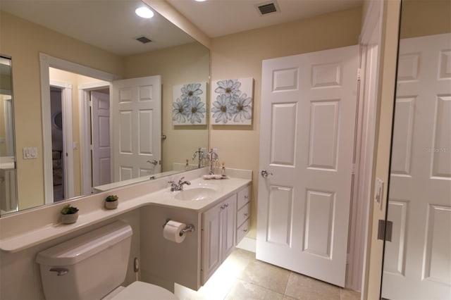 bathroom featuring vanity, tile patterned flooring, and toilet