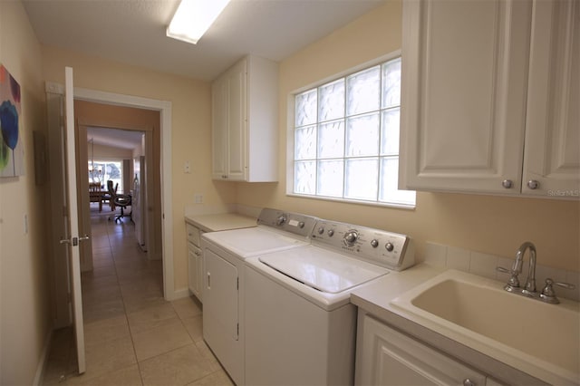 clothes washing area with cabinets, washer and clothes dryer, sink, and light tile patterned floors