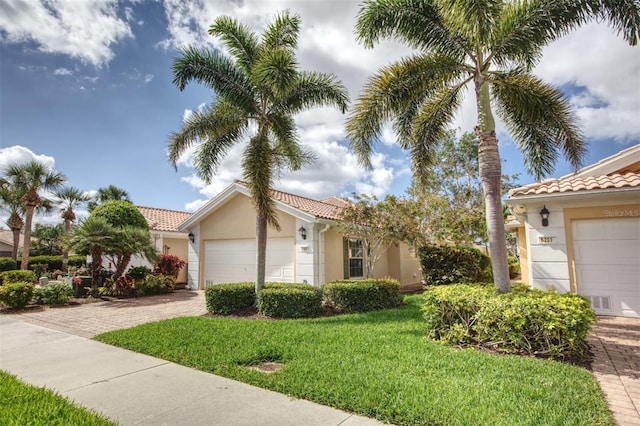 mediterranean / spanish home with a garage and a front yard