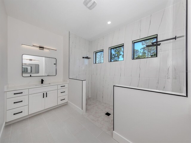 bathroom featuring tiled shower, tile floors, and vanity with extensive cabinet space