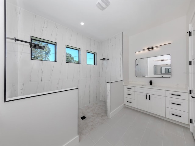 bathroom featuring a tile shower, tile floors, and large vanity