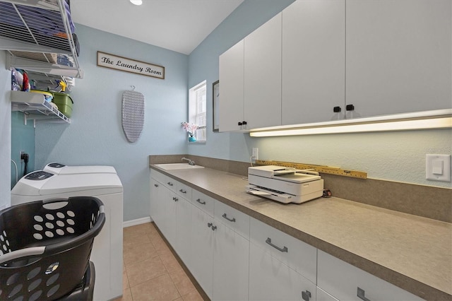 laundry area featuring cabinets, sink, light tile floors, and washer and clothes dryer