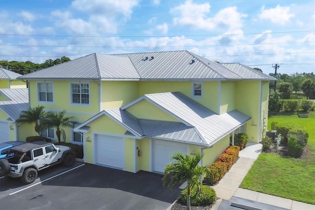 view of front of home with a front lawn, a garage, and central AC unit