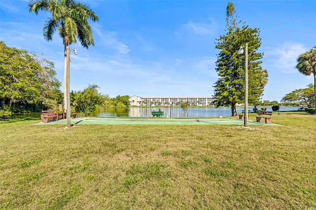 surrounding community with a lawn and a water view