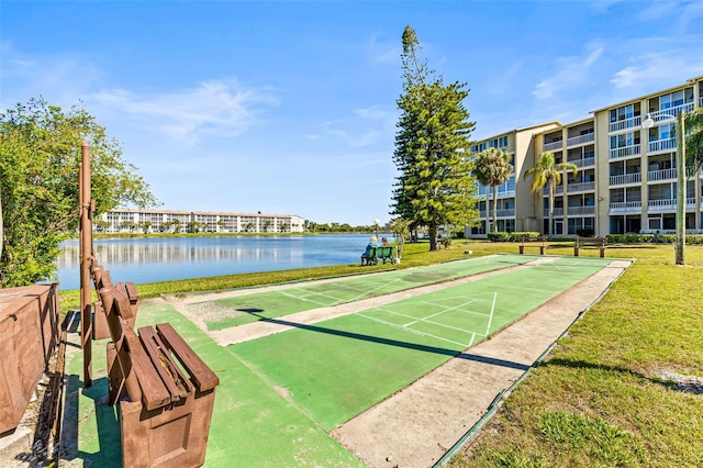 view of community featuring a lawn and a water view