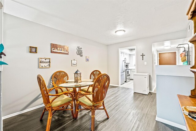 dining room featuring a textured ceiling and hardwood / wood-style floors