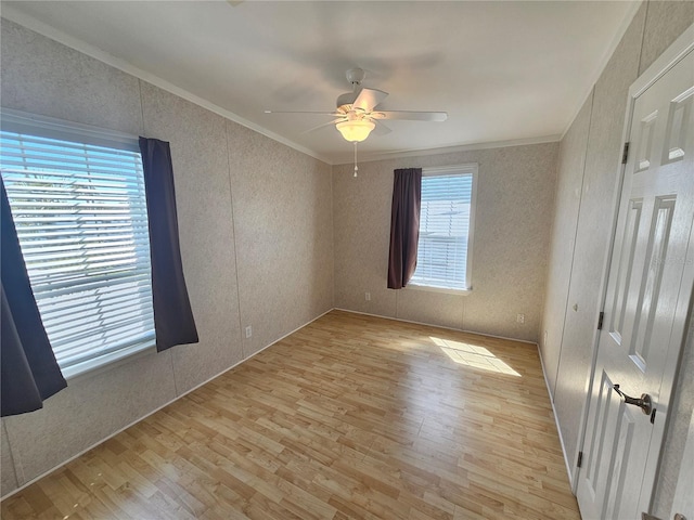 unfurnished bedroom with ceiling fan, light hardwood / wood-style floors, crown molding, and multiple windows