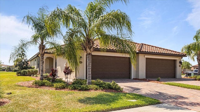 mediterranean / spanish-style house featuring a garage and a front yard