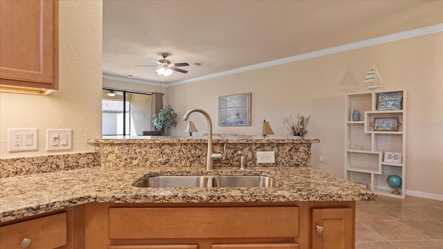 kitchen with sink, ceiling fan, light tile floors, and light stone counters