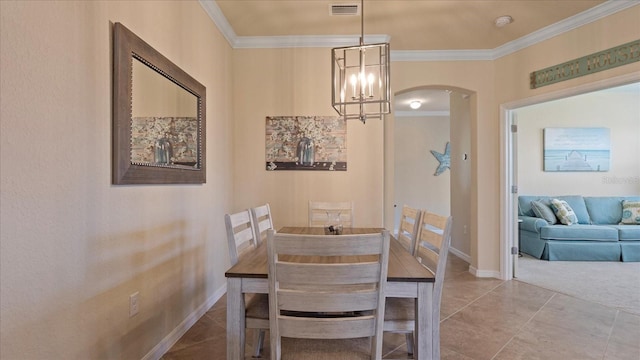 dining room with ornamental molding, an inviting chandelier, and light tile floors