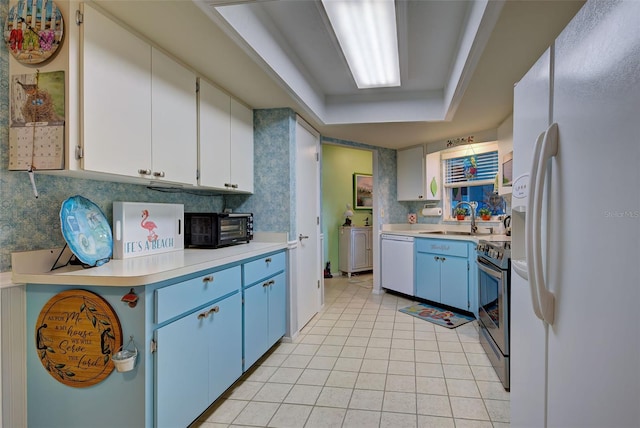 kitchen featuring blue cabinetry, white appliances, white cabinetry, sink, and light tile floors