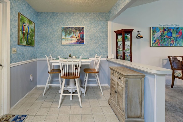 tiled dining space featuring a textured ceiling