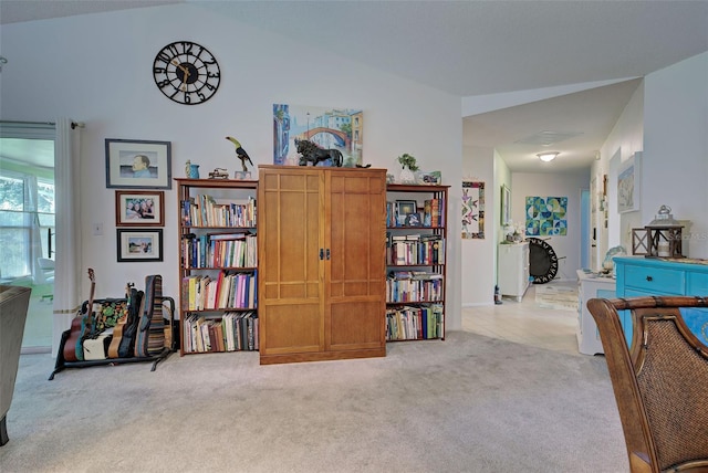 interior space featuring vaulted ceiling and light carpet