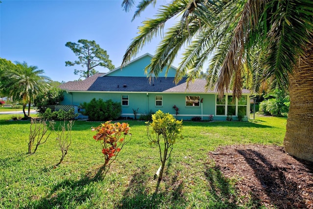 rear view of house featuring a lawn