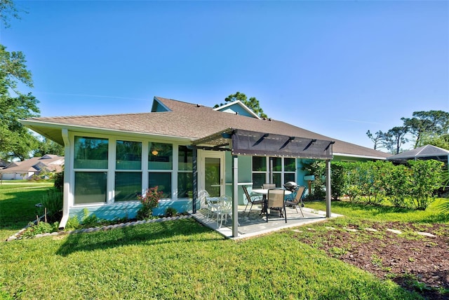 rear view of property with a patio area, a pergola, and a lawn