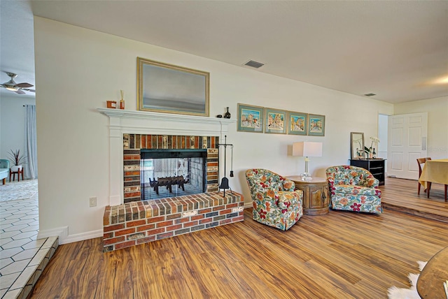 living room with hardwood / wood-style flooring and a brick fireplace