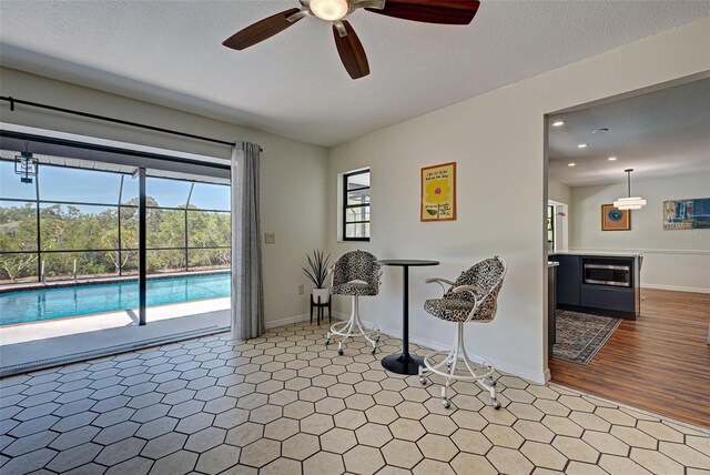 interior space with ceiling fan and a textured ceiling