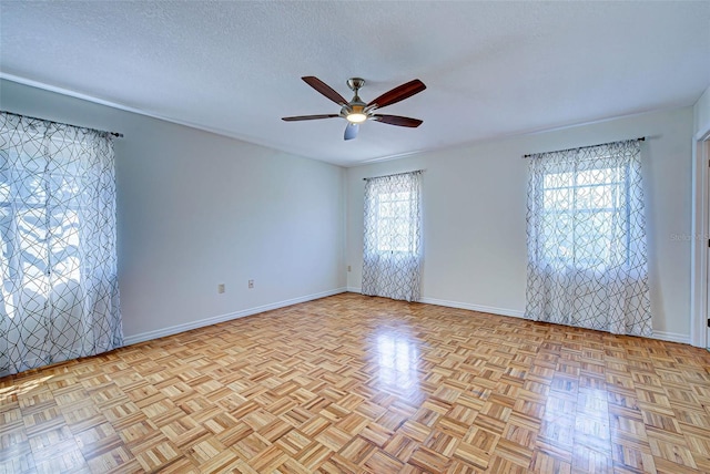 spare room with ceiling fan, light parquet floors, and a textured ceiling