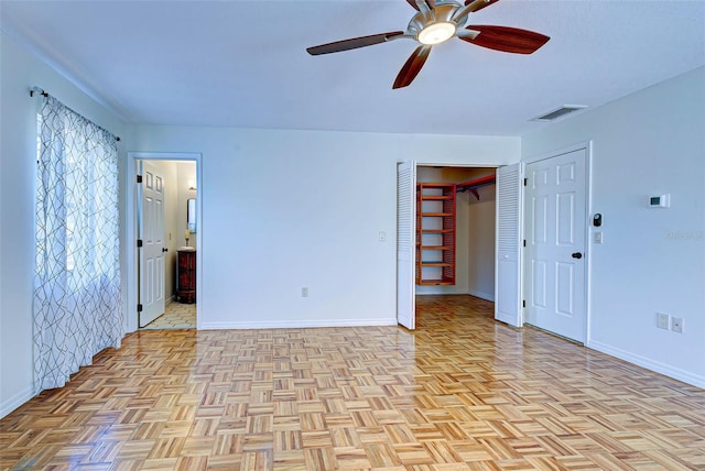 empty room with ceiling fan and light parquet floors