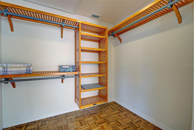 walk in closet with dark parquet floors