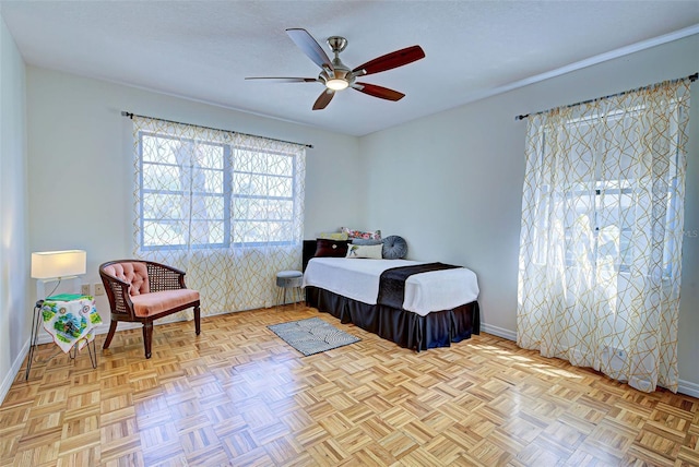 bedroom featuring ceiling fan, light parquet flooring, and a textured ceiling