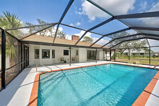 view of swimming pool featuring ceiling fan, a patio, and a lanai