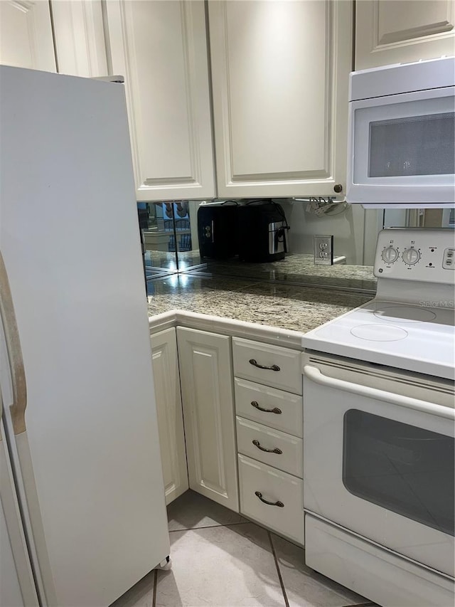 kitchen featuring white cabinets, light tile patterned floors, and white appliances