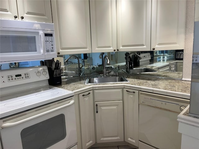 kitchen with white cabinets, white appliances, and sink