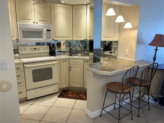 kitchen featuring kitchen peninsula, pendant lighting, electric range, a breakfast bar area, and light tile patterned flooring