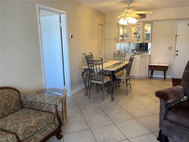 tiled dining space with ceiling fan