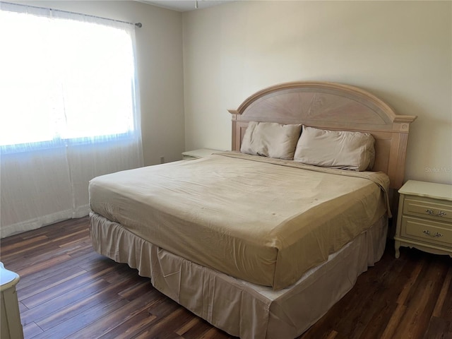 bedroom with dark hardwood / wood-style flooring