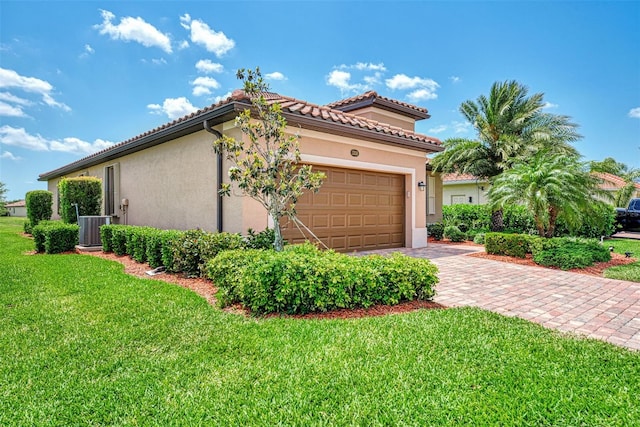 mediterranean / spanish-style home with a front yard, a garage, and central AC