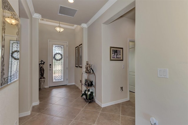 foyer with crown molding and light tile floors