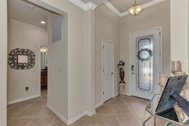 tiled foyer entrance featuring crown molding