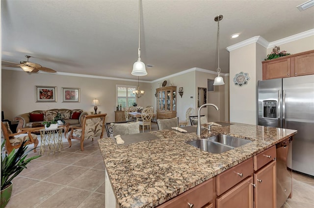 kitchen featuring light tile floors, sink, ceiling fan with notable chandelier, an island with sink, and pendant lighting