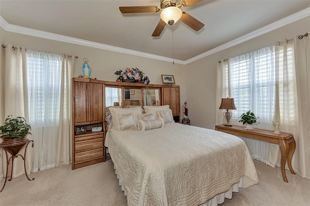 carpeted bedroom with ornamental molding and ceiling fan