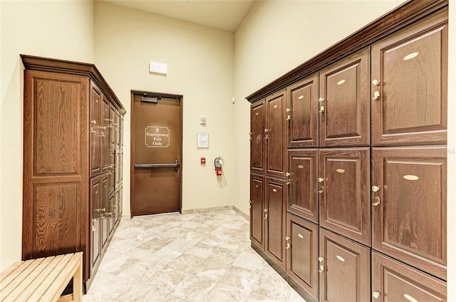 corridor with a towering ceiling and light tile floors