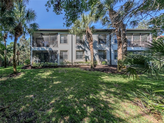 exterior space with ceiling fan, a balcony, and a front yard