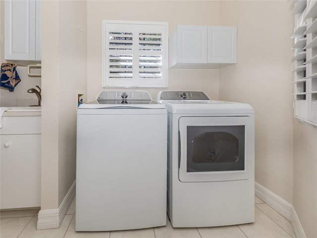 washroom with washer and clothes dryer, sink, light tile patterned floors, and cabinets