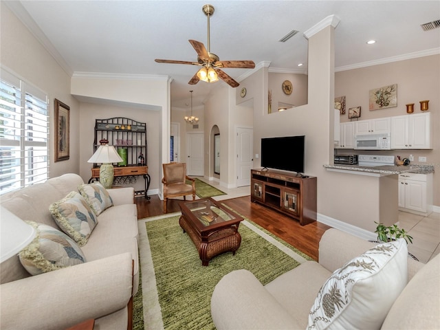 living room with ceiling fan, ornamental molding, and light hardwood / wood-style floors