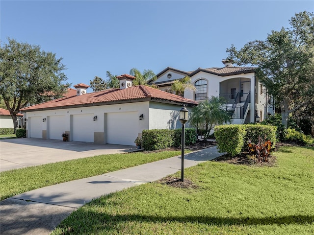 mediterranean / spanish house featuring a garage, a front lawn, and a balcony