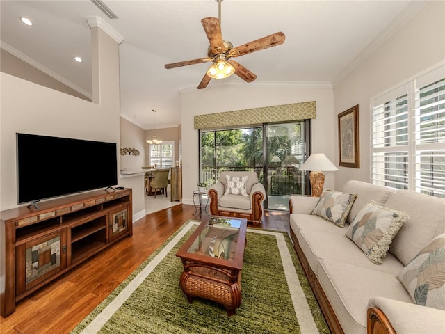 living room featuring lofted ceiling, a wealth of natural light, ornamental molding, and hardwood / wood-style flooring