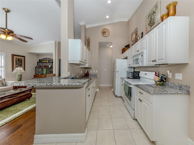 kitchen featuring white cabinetry, kitchen peninsula, white appliances, crown molding, and light stone counters