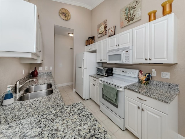 kitchen with white appliances, white cabinets, sink, light tile patterned flooring, and light stone counters