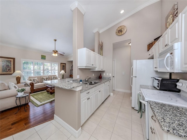 kitchen with light tile patterned floors, white appliances, white cabinets, light stone counters, and sink