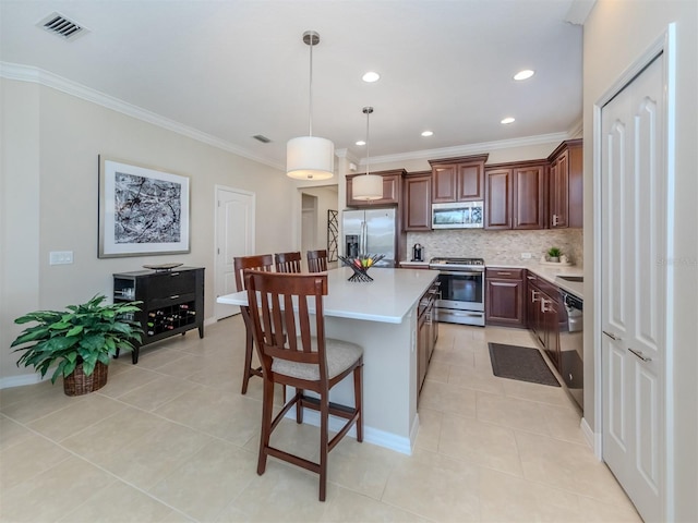 kitchen with hanging light fixtures, a kitchen island, stainless steel appliances, a breakfast bar, and light tile floors